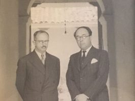 A couple of men standing in a doorway AI-generated content may be incorrect.